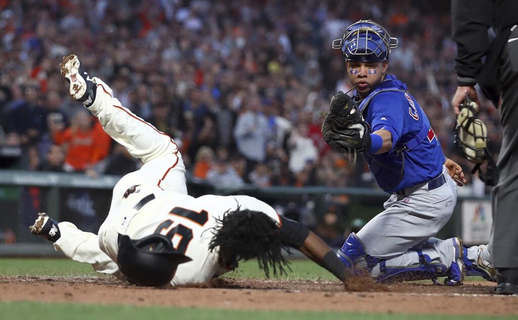 San Francisco Giants' Alen Hanson, left, tumbles after scoring against Chicago Cubs catcher Willson Contreras in the fifth inning of a baseball game Monday, July 9, 2018, in San Francisco. (AP Photo/Ben Margot)