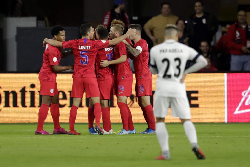 U.S players celebrate a goal by Weston McKennie, left, as Cuba's Luis Paradela (23) stands nearby during the first half of a CONCACAF Nations League soccer match Friday, Oct. 11, 2019, in Washington. (AP Photo/Julio Cortez)