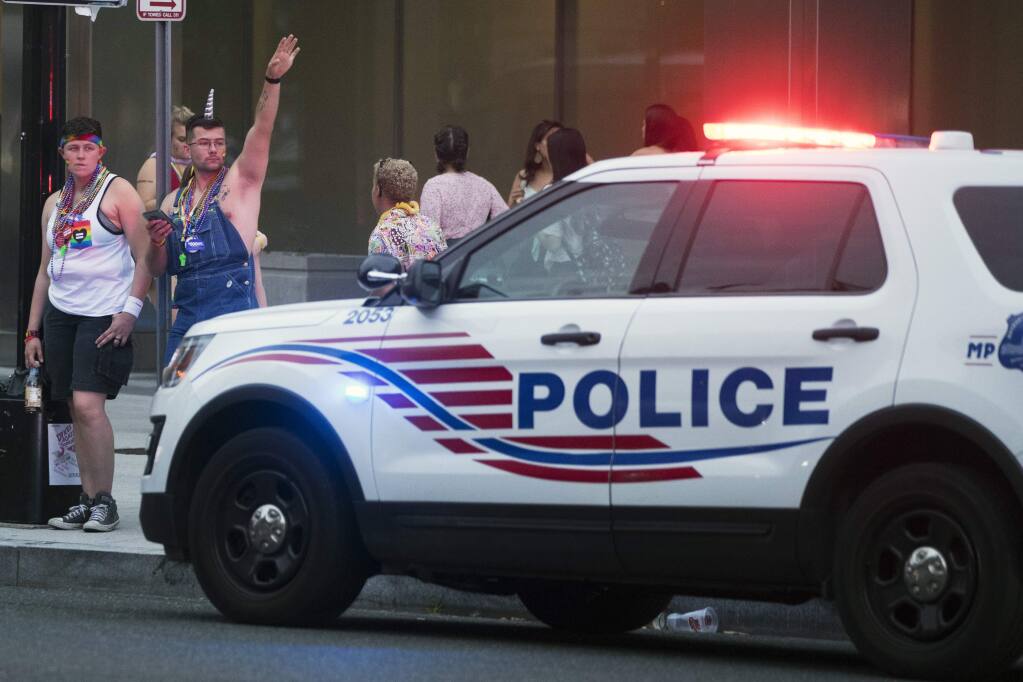 Police keep watch at Dupont Circle at the conclusion of the Capitol Pride Parade in Washington, Saturday, June 8, 2019. Officials in Washington say several people were injured after a panic at the LGBTQ pride parade sent people running through the streets of the nation's capital. (AP Photo/Andrew Harnik)