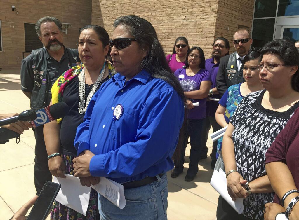 FILE - In this Tuesday, Aug. 1, 2017 file photo Gary Mike, front, father of 11-year-old Ashlynne Mike, speaks outside of federal court in Albuquerque, N.M. The man who admitted to killing the Navajo girl, Ashlynne Mike, faces life in prison without parole. Ashlynne Mike's mother has been urging the tribe to opt in to the death penalty, particularly for crimes that involve children. But the Southwestern tribe has long objected to putting people to death. The culture teaches that all life is precious. (AP Photo/Russell Contreras, File)