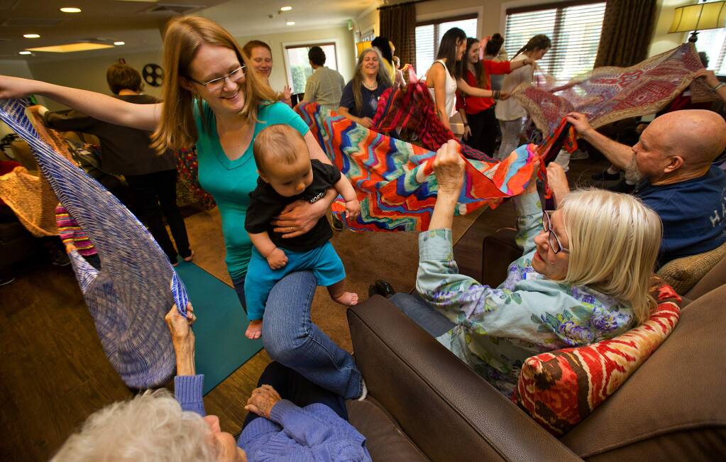 Kayla Flores Tindall dances and sings with her son Amani, 6 months while Betty Wooley, Marilyn Stewart and Ron Casera help on the other end of scarfs during a Music Together class at the Sunrise Villa in Santa Rosa on Friday, March 9, 2018. (photo by John Burgess/The Press Democrat)