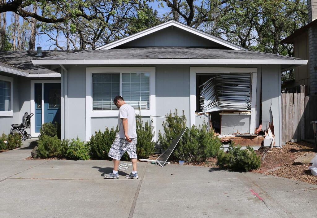 Donald Marlatt walks past the damged exterior of his home on Calavares Drive, after a hit and run driver crashed into his 11-year-old son's bedroom pushing him into a closet early Monday morning.