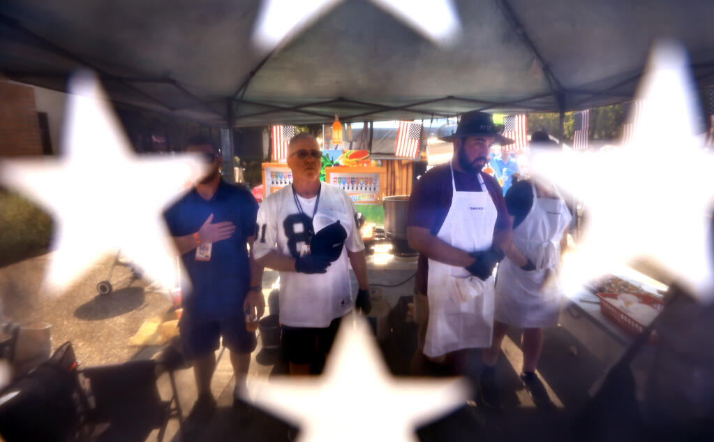 Windsor residents, from left, D.J.Edgar, Stan Edgar and Dan Quinones stand for the National Anthem during the Windsor Chili Cook off, Saturday, Sept. 10, 2022 in Windsor. (Kent Porter / The Press Democrat) 2022