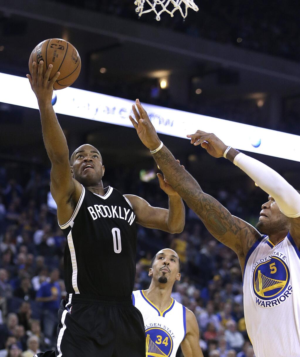 Brooklyn Nets' Jarrett Jack, left, lays up a shot past Golden State Warriors' Marreese Speights (5) during the first half of an NBA basketball game Thursday, Nov. 13, 2014, in Oakland, Calif. (AP Photo/Ben Margot)
