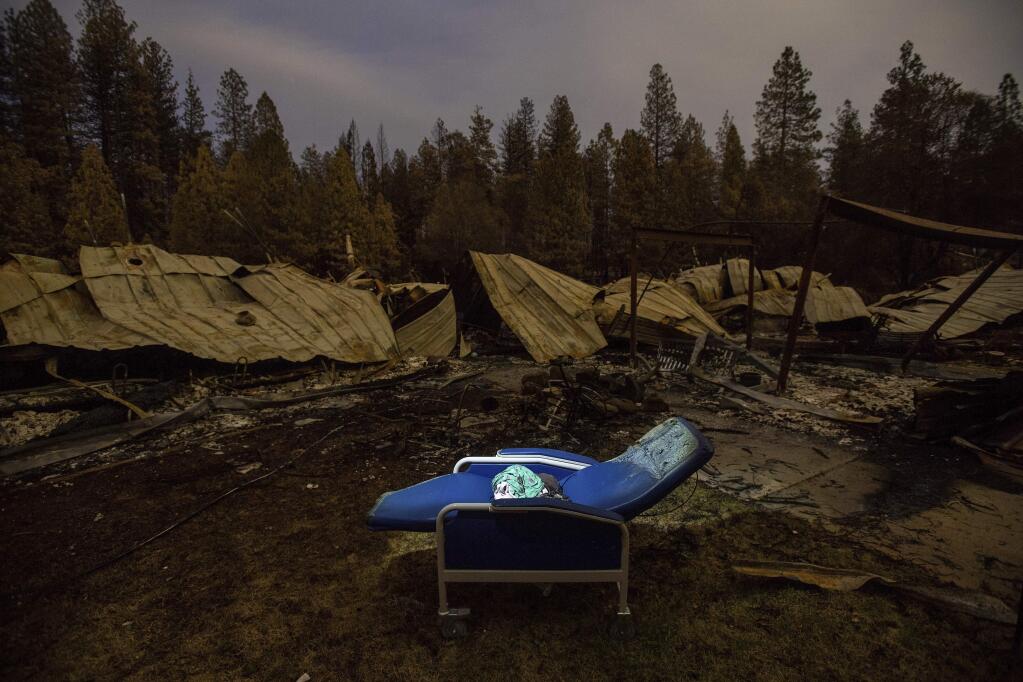 A chair rests outside Cypress Meadows Post-Acute, a nursing home leveled by the Camp Fire, on Tuesday, Dec. 4, 2018, in Paradise, Calif. (AP Photo/Noah Berger)