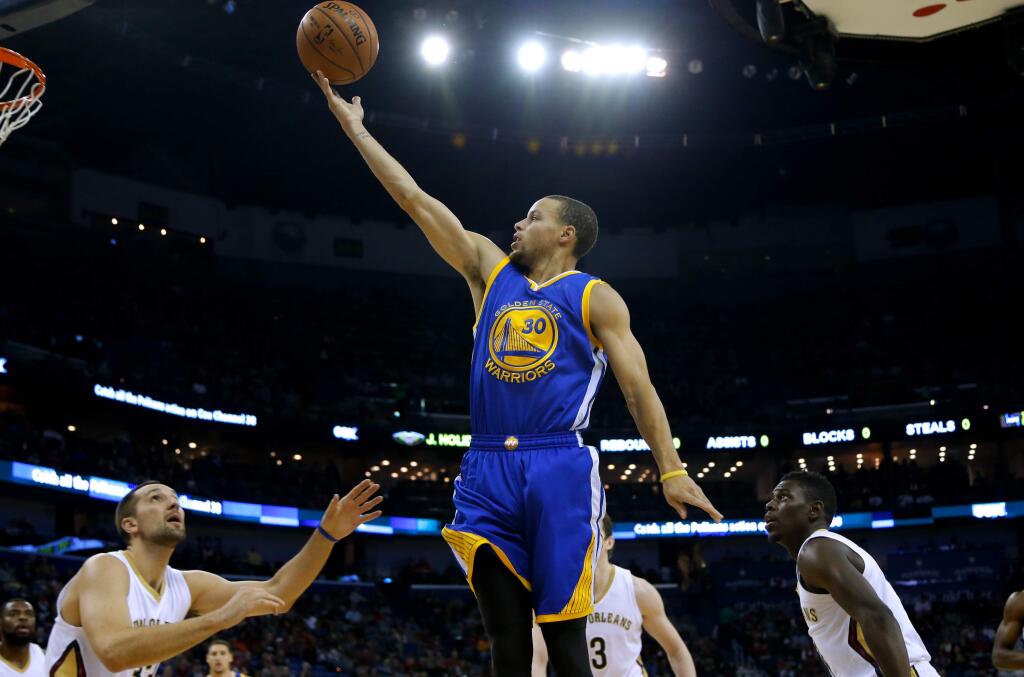 Golden State Warriors guard Stephen Curry (30) shoots over New Orleans Pelicans forward Ryan Anderson, left, and guard Jrue Holiday, right, during the first half of an NBA basketball game in New Orleans, Sunday, Dec. 14, 2014. (AP Photo/Jonathan Bachman)