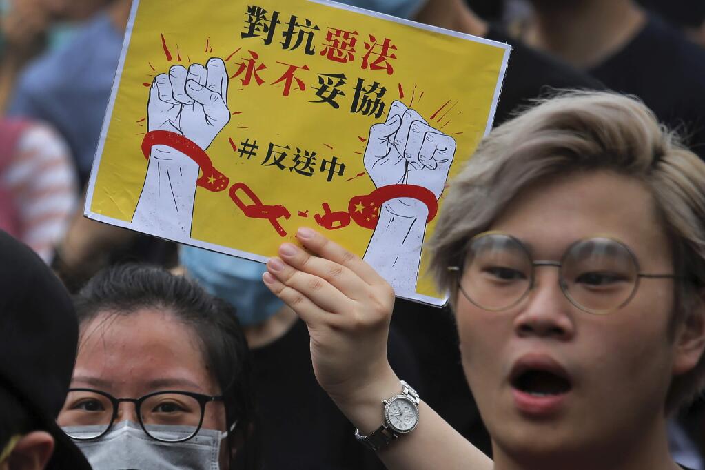 Protesters hold a poster as they chant slogans near the Legislative Council as they continuing protest against the unpopular extradition bill in Hong Kong, Monday, June 17, 2019. A member of Hong Kong's Executive Council says the city's leader plans to apologize again over her handling of a highly unpopular extradition bill. (AP Photo/Kin Cheung)