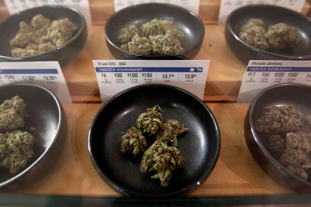 FILE- In this Jan. 1, 2018 file photo, different types of marijuana sit on display at Harborside marijuana dispensary in Oakland, Calif. Sen. Cory Gardner of Colorado announced Friday, April 13, 2018 that President Trump has pledged to support legislation protecting the marijuana industry in states that have legalized the drug. Gardner has been pushing to reverse a decision made by Attorney General Jeff Sessions in January that removed prohibitions that kept federal prosecutors from pursuing cases against people who were following state pot laws. (AP Photo/Mathew Sumner, File)
