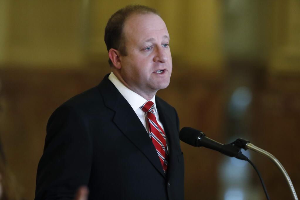 In this Monday, March 16, 2020, photograph, Colorado Gov. Jared Polis makes a point during a news conference about the state's efforts to fend off the spread of coronavirus in Denver. On Monday, March 23, Polis signed a bill to make Colorado the 22nd state in the union to abolish the death penalty and commute the sentences of the state's three death-row inmates to life in prison. (AP Photo/David Zalubowski)