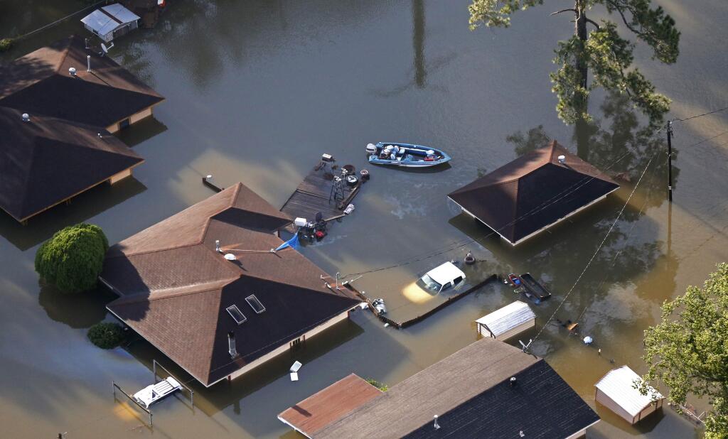 A boat sits near flooded homes in the aftermath of Tropical Storm Harvey in Beaumont, Texas, Thursday, Aug. 31, 2017. (AP Photo/Gerald Herbert)