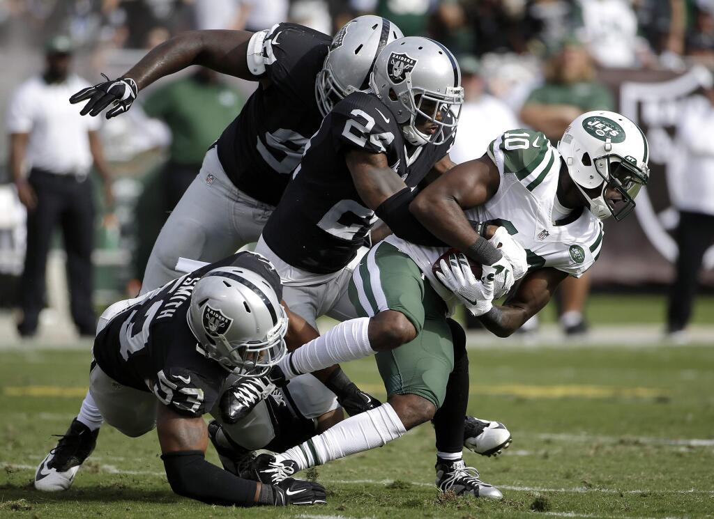 New York Jets wide receiver Kenbrell Thompkins (10) is tackled by Oakland Raiders cornerback Charles Woodson (24), linebacker Malcolm Smith (53) and defensive end Mario Edwards Jr. during the first half Sunday, Nov. 1, 2015. (AP Photo/Marcio Jose Sanchez)