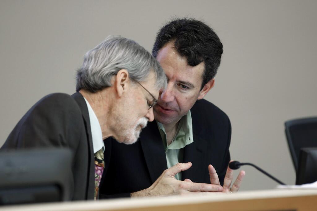 California Air Resources Board members Alexander Sherriffs, left, and Hector De La Torre confer as the board discussed restoring rules to cut transportation fuel emissions 10 percent within 5 years, during a hearing in Sacramento, Calif., Friday, Sept. 25, 2015. By a 9-0 vote the board restored rules requiring a 10 precent cut in carbon emissions on fuels sold in the state by 2020 despite oil industry objections that it could drive up gas prices. (AP Photo/Rich Pedroncelli)