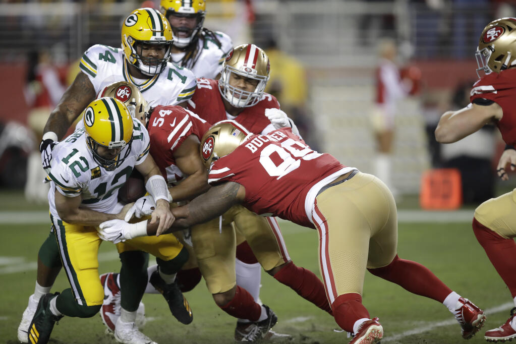 Green Bay Packers quarterback Aaron Rodgers, left, fumbles the ball while sacked by San Francisco 49ers middle linebacker Fred Warner, No. 54, during the first half in Santa Clara on Sunday, Nov. 24, 2019. (Ben Margot / ASSOCIATED PRESS)