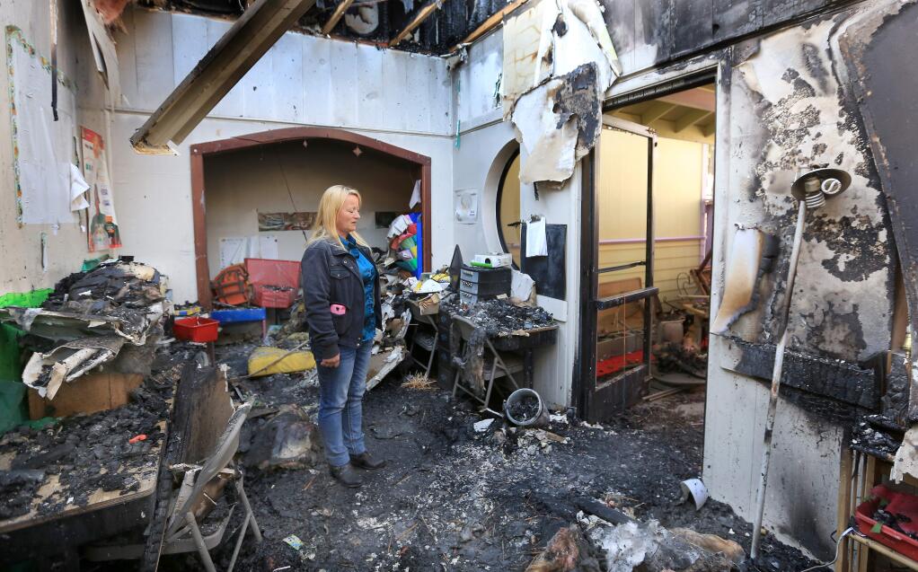 Saprina Rodriguez, the owner of Imagination Station Preschool in Willits , surveys what is left of her day care center, Monday Nov. 17, 2014 after an early Friday morning fire gutted the school and two other businesses in the close knit community. (Kent Porter / Press Democrat) 2014