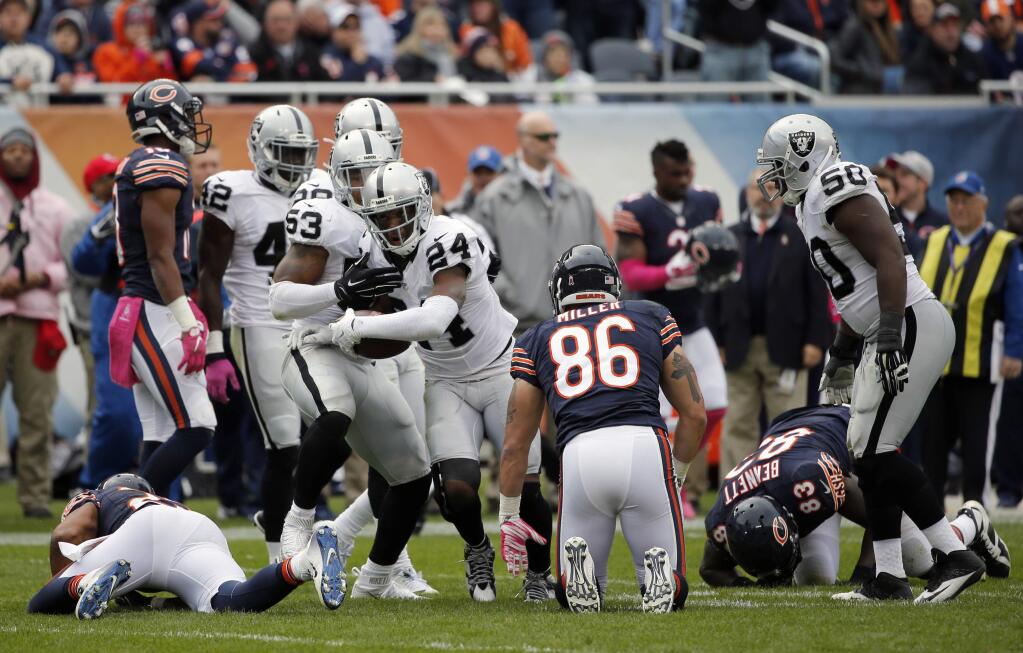 Oakland Raiders free safety Charles Woodson (24) celebrates after intercepting a pass during the second half of an NFL football game against the Chicago Bears, Sunday, Oct. 4, 2015, in Chicago. (AP Photo/Charles Rex Arbogast)