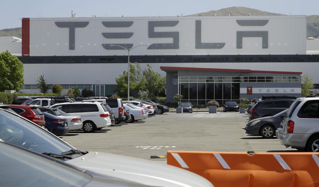 Vehicles are seen parked at the Tesla plant Monday, May 11, 2020, in Fremont, Calif. (AP Photo/Ben Margot)