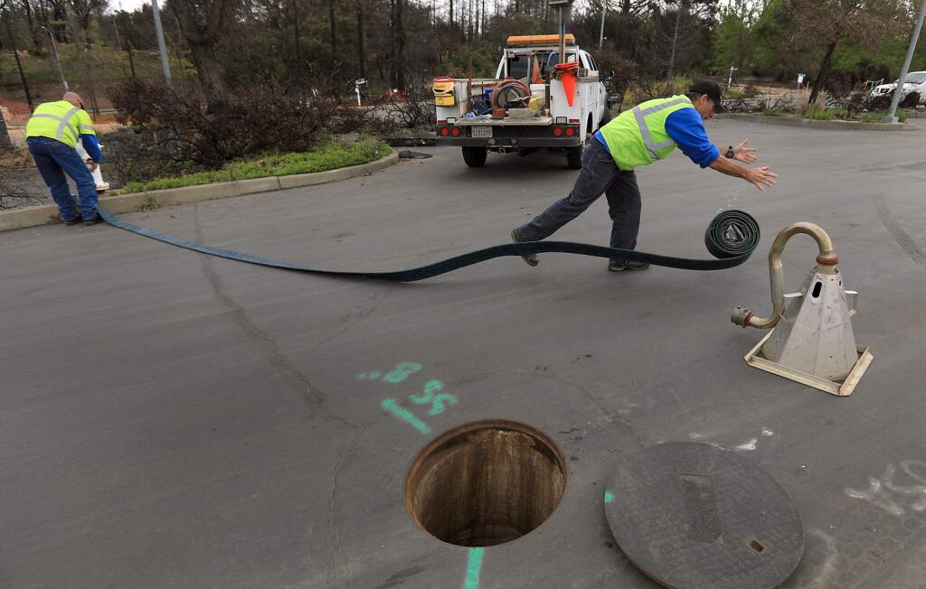 Anthony Drolet, left, and Tom Lynn, utility systems operators with the City of Santa Rosa, prepare to flush a water line in the Foutaingrove area of Santa Rosa, Wednesday, May 16, 2018, (Kent Porter / The Press Democrat) 2018