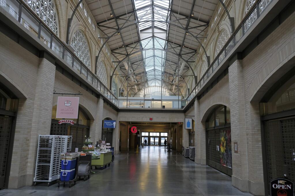 The main hallway of the Ferry Building Marketplace is mostly empty Monday, March 16, 2020, in San Francisco. Millions of California's oldest and youngest residents stayed home Monday as officials took increasingly strident steps to separate people and contain the spread of the coronavirus. Evidence that people were staying home included traffic flowing freely on some freeways that are normally congested during rush hours.(AP Photo/Eric Risberg)