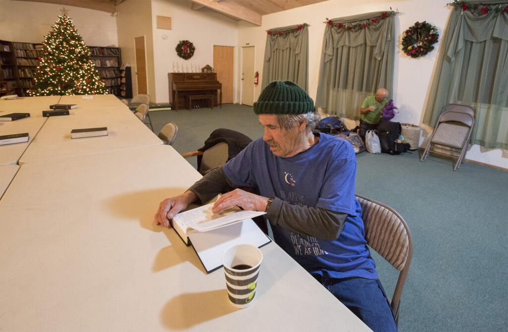 Before bedding down for the night, John Fassio has a drink and a read at the Sonoma Alliance Church. (Photo by Robbi Pengelly/Index-Tribune)