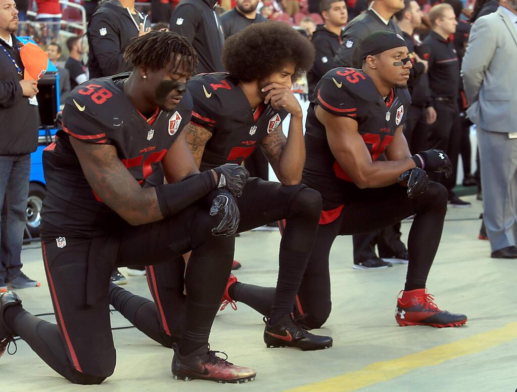 Colin Kaepenick leads Eli Harold, left and Eric Reid as they keep their protest going during the National Anthem, Thursday Oct.6, 2016 at Levi's Stadium in Santa Clara. (Kent Porter / The Press Democrat)