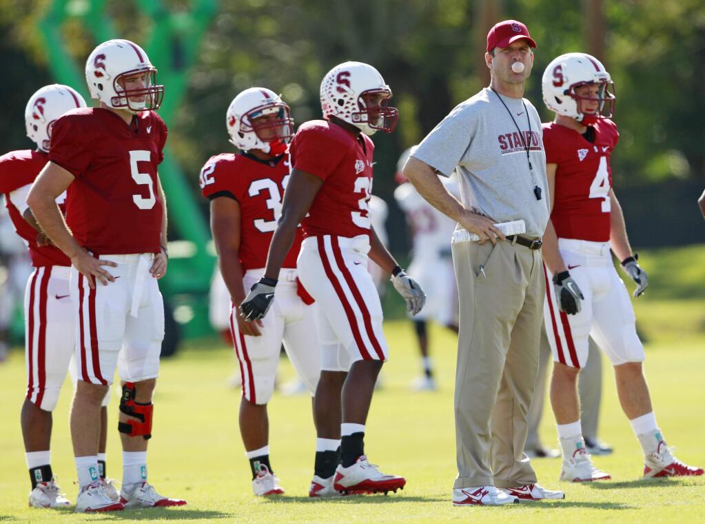 Jim Harbaugh, second from right, who coached at Stanford from 2007-2010, could be headed back to the college coaching ranks. (HANS DERYK / Associated Press)