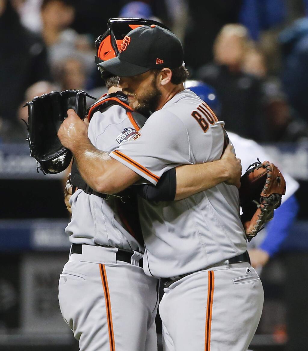 San Francisco Giants starting pitcher Madison Bumgarner, right, hugs San Francisco Giants catcher Buster Posey (28) after pitching a complete game against the New York Mets in the National League wild-card game, Wednesday, Oct. 5, 2016, in New York. The Giants won 3-0. (AP Photo/Kathy Willens)