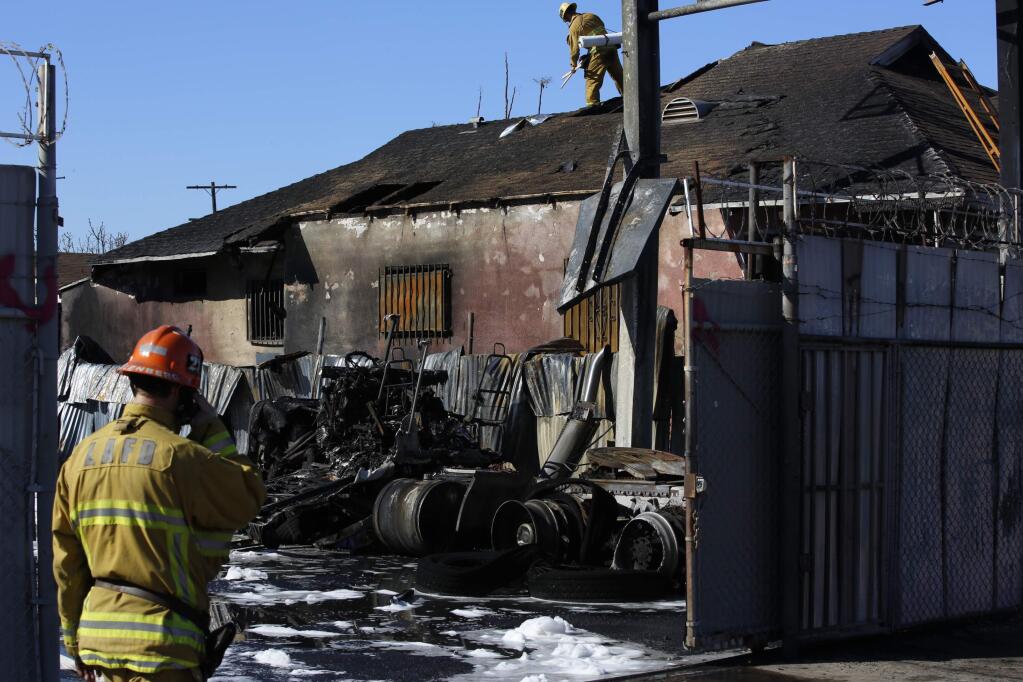 Firefighters work at the scene of a fire after an explosion in Los Angeles Sunday, March 17, 2019. Authorities said multiple people were hurt in the explosion following reports of an underground gas leak in South Los Angeles. (AP Photo/Damian Dovarganes)