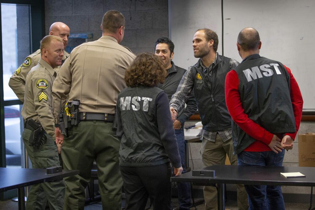 Members of the Mobile Support Team, a group of mental health specialist employed by the county, meet with Sheriff's deputies to talk about the day's calls and how to decelerate situations involving acute mental health issues. (JOHN BURGESS / The Press Democrat)