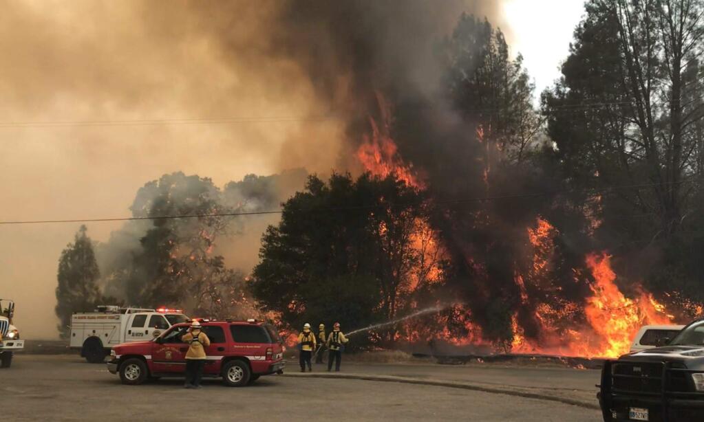 In this photo provided by the Cal Fire Communications, firefighters battle a wildfire in an area northeast of Clearlake Oaks, Calif., Sunday, June 24, 2018 Wind-driven wildfires destroyed buildings and threatened hundreds of others Sunday as they raced across dry brush in rural Northern California. (Jonathan Cox/Cal Fire Communications via AP)