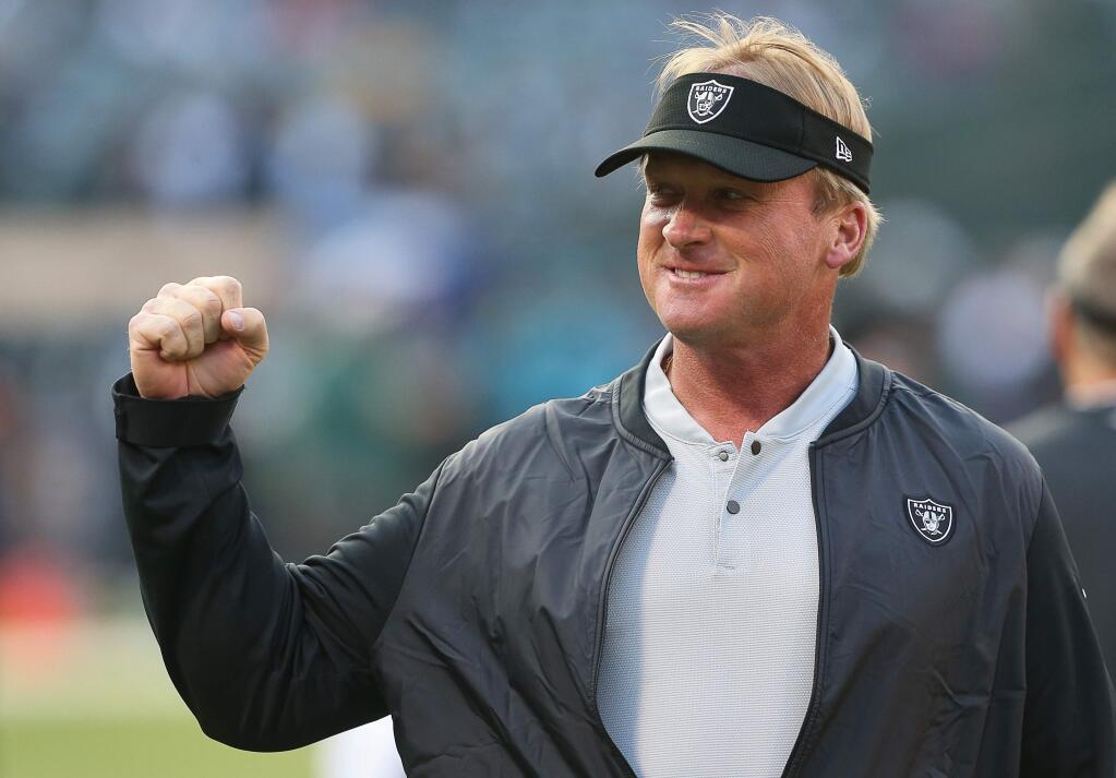Oakland Raiders head coach Jon Gruden pumps his fists towards fans as his team warms up before playing the Green Bay Packers in Oakland on Friday, Aug. 24, 2018. (Christopher Chung / The Press Democrat)