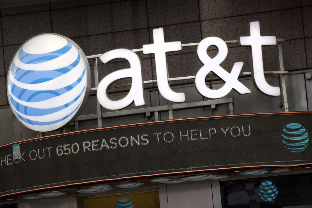 FILE - In this Monday, Oct. 24, 2016, file photo, the AT&T logo is positioned above one of its retail stores in New York. (AP Photo/Mark Lennihan, File)