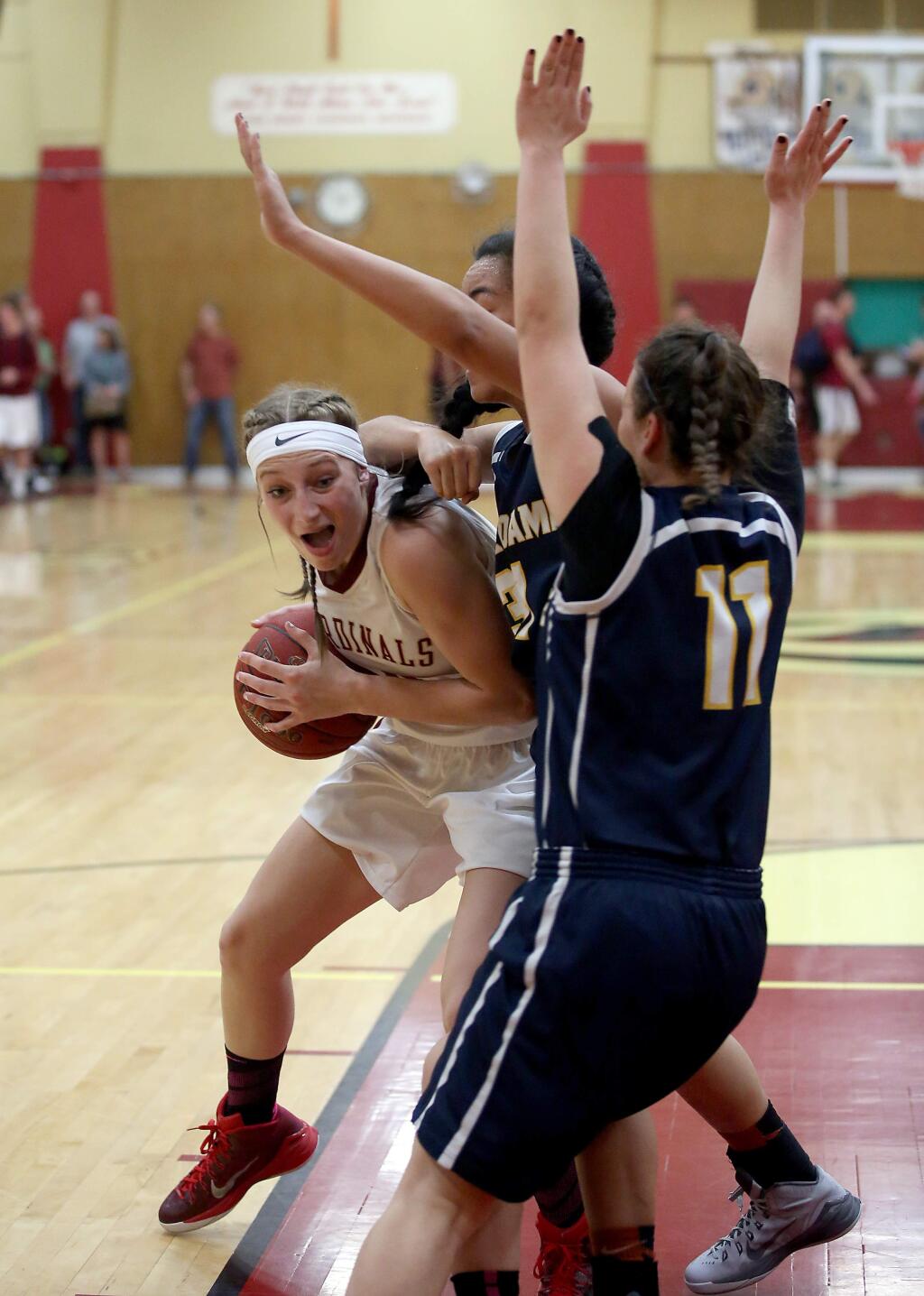 Cardinal Newman's Tiffany Salinas tries to push past Notre Dame's Limu Vanisi, center, and Eleni Giotinis, right during the game held at Cardinal Newman High School, Saturday, March 14, 2015. (CRISTA JEREMIASON / The Press Democrat)