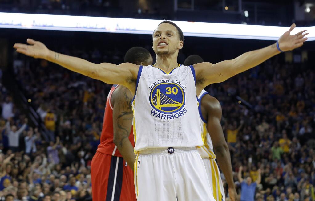 Golden State Warriors guard Stephen Curry (30) celebrates after scoring against the Washington Wizards during the second half of an NBA basketball game in Oakland, Calif., Monday, March 23, 2015. (AP Photo/Jeff Chiu)