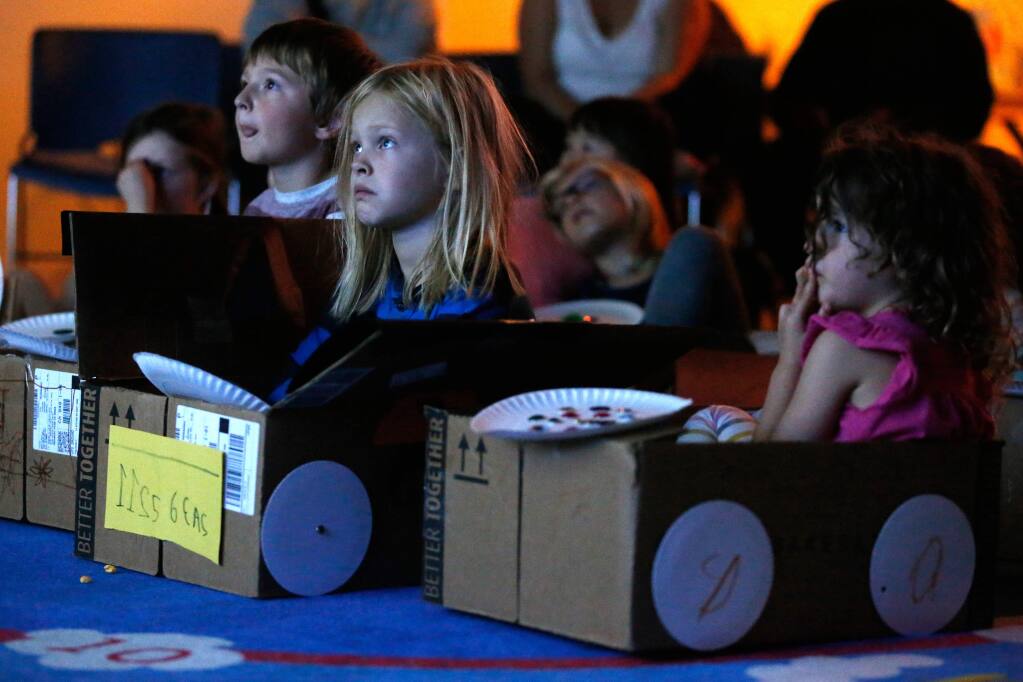 Ezra Lunden, 7, second from left, and other children sit in boxes decorated as cars for a 'drive-in' movie at Petaluma Regional Library in Petaluma, California, on Friday, November 2, 2018. (Alvin Jornada / The Press Democrat)
