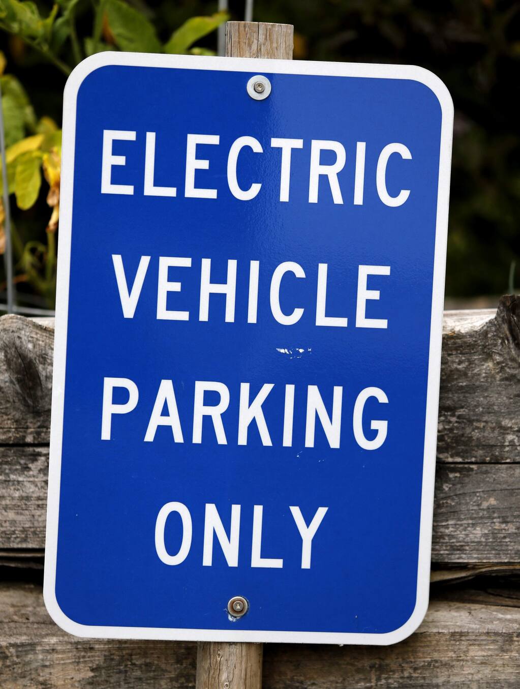 An 'electric vehicle parking only' sign is posted in the parking space where Carl Mears charges his Nissan Leaf electric car at his condo complex in Cotati, on Thursday, July 9, 2015. (BETH SCHLANKER/ The Press Democrat)