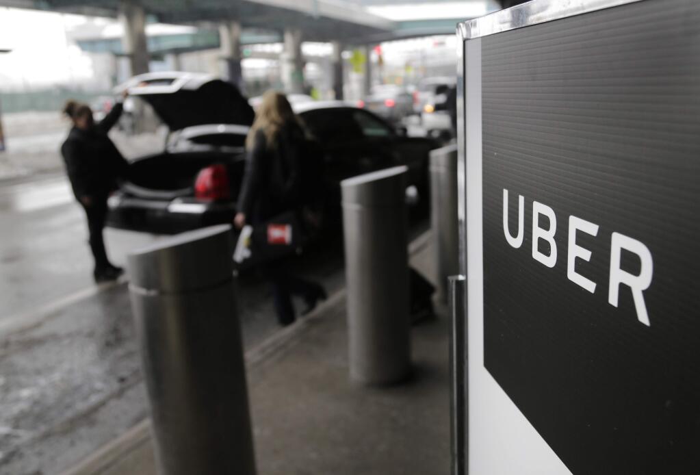 FILE - In this March 15, 2017, file photo, a sign marks a pick-up point for the Uber car service at LaGuardia Airport in New York. The New York Times and other media are reporting Sunday, June 11, 2017, that Uber's board is considering placing Kalanick, the CEO of the ride-hailing company, on leave. (AP Photo/Seth Wenig, File)