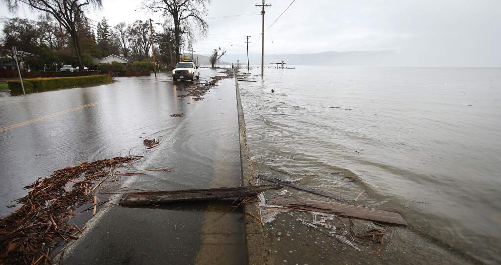 A Lakeport city crew checks on Lakeshore Boulevard at the edge of Clear Lake in Lakeport, Tuesday Feb. 21, 2017. (Kent Porter / The Press Democrat)