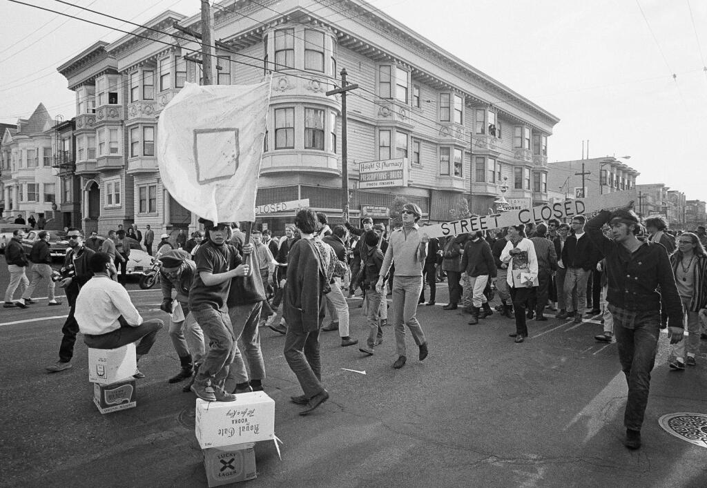 In this April 3, 1967 file photo, people parade up and down the streets of the Haight-Ashbury district in San Francisco. They came for the music, the mind-bending drugs, to resist the Vietnam War and 1960s American orthodoxy, or simply to escape summer boredom. And they left an enduring legacy. Fifty years ago, throngs of American youth descended on San Francisco to join a cultural revolution. (AP Photo/Robert W. Klein, File)