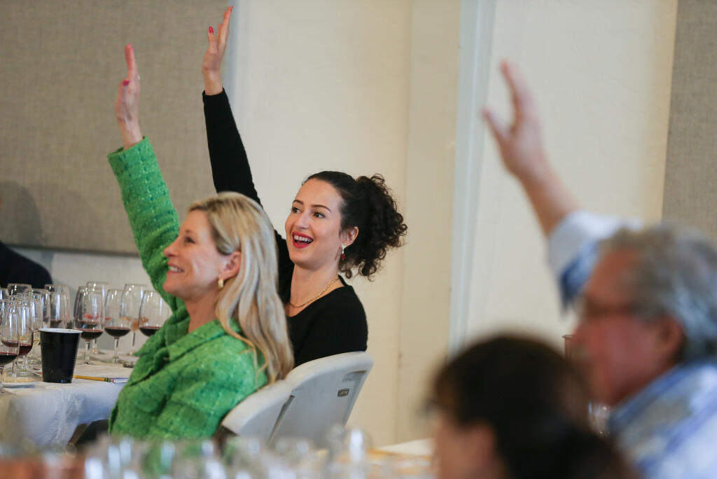 Alex Sarovich, right, and Liz Thach vote in support of a wine during the second day of judging at the North Coast Wine Challenge in Santa Rosa, Wednesday, April 3, 2024.  (Christopher Chung / The Press Democrat)