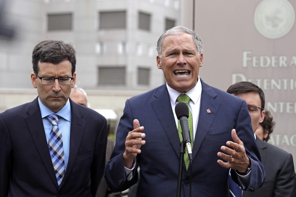Washington Gov. Jay Inslee, right, speaks as Attorney General Bob Ferguson looks on at a news conference announcing a lawsuit against the Trump administration over a policy of separating immigrant families illegally entering the United States, in front of the Federal Detention Center Thursday, June 21, 2018, in SeaTac, Wash. Ferguson made the announcement outside the federal prison south of Seattle, where about 200 immigration detainees have been transferred - including dozens of women separated from their children under the administration's 'zero tolerance' policy. (AP Photo/Elaine Thompson)