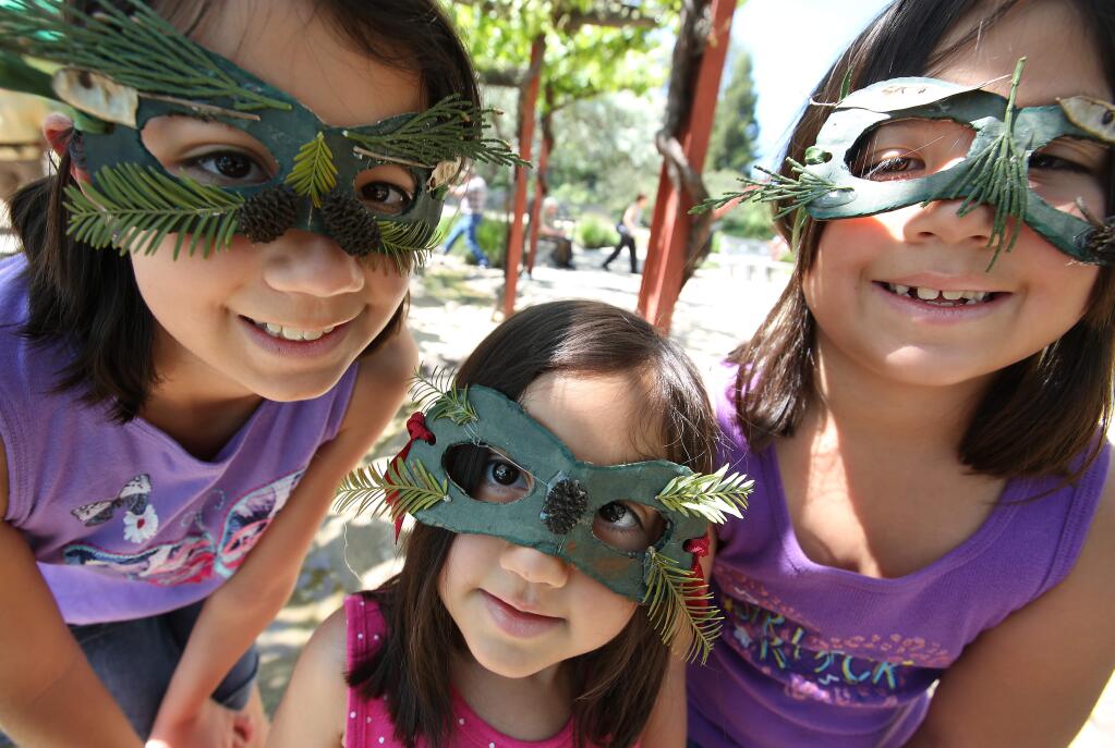 Liana Macias, 10, left, and her sisters Elodie, 3, center, and Bryn, 7, right, show off their super hero environmental masks during the Earth Day festivities at The Solar Living Center in Hopland, Saturday, April 18, 2015. (CRISTA JEREMIASON / The Press Democrat)