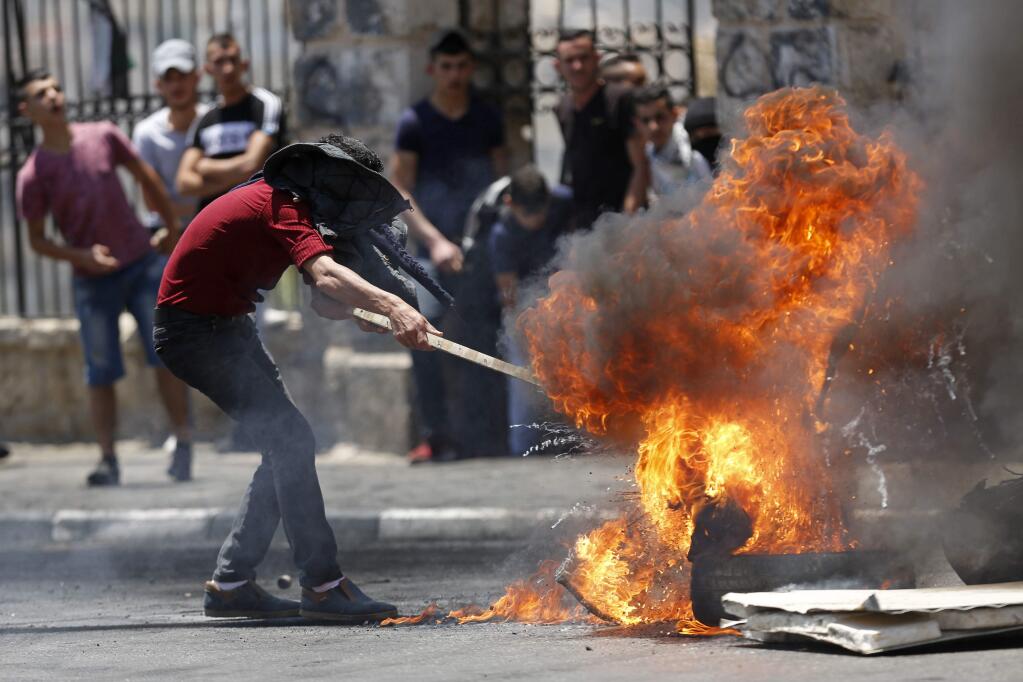 Palestinians burn tires during clashes with Israeli forces after a rally to mark the 70th anniversary of what Palestinians call their 'nakba,' or catastrophe - the uprooting of hundreds of thousands in the Mideast war over Israel's 1948 creation, in the West Bank city of Bethlehem, Tuesday, May 15, 2018. (AP Photo/Majdi Mohammed)