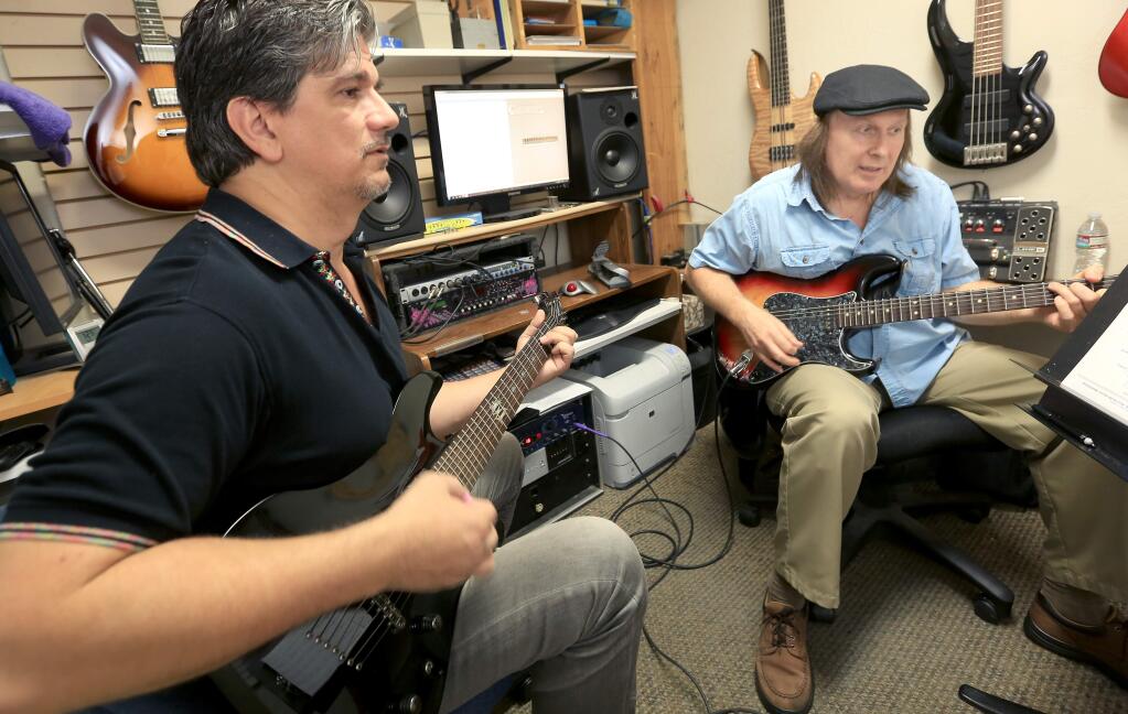 Bill Decker teaches Greg Beckham, left, the finer points of guitar playing, Thursday Sept. 25, 2014 at Stanroy Music Center in Santa Rosa. (Kent Porter / Press Democrat) 2014