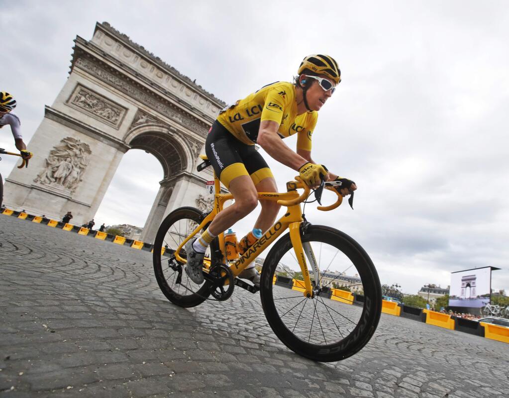 Tour de France winner Britain's Geraint Thomas, wearing the overall leader's yellow jersey, passes the Arc de Triomphe during the twenty-first stage of the Tour de France cycling race over 116 kilometers (72.1 miles) with start in Houilles and finish on Champs-Elysees avenue in Paris, France, Sunday July 29, 2018. (AP Photo/Christophe Ena)