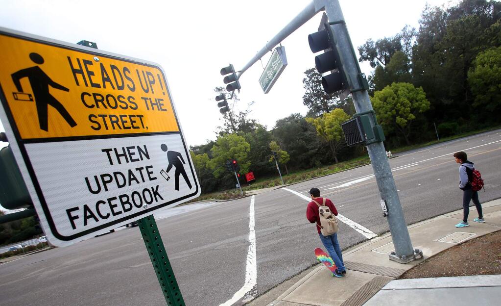 In this Feb. 9, 2015 photo, a new pedestrian crossing sign sits along Carlos Bee Boulevard in Hayward, Calif. The city is using humor to get drivers to slow down and pedestrians to pay attention. (AP Photo/The Contra Costa Times, Aric Crabb)