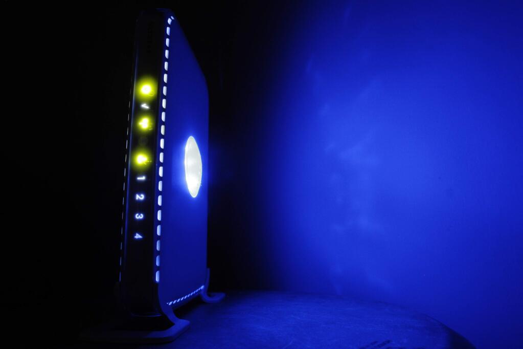 FILE- This July 27, 2008, file photo shows a, LED-illuminated wireless router in Philadelphia. Officials from the United States and Europe are announcing charges against 10 people in connection with malicious software attacks that infected tens of thousands of computers and caused more than $100 million in financial losses.(AP Photo/Matt Rourke, File)