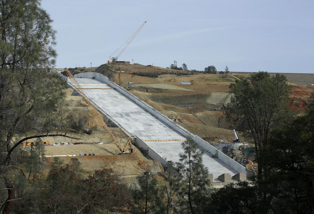FILE - In this Nov. 30, 2017, file photo, work continues on the Oroville Dam spillway in Oroville, Calif. California water officials plan to update a Northern California community about their efforts to repair the nation's tallest dam after damage to its spillways forced nearly 200,000 people to evacuate last February. (AP Photo/Rich Pedroncelli, File)