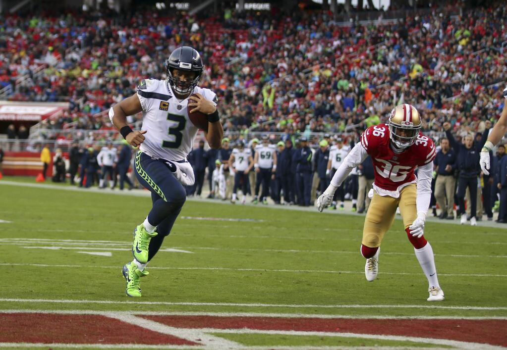 Seattle Seahawks quarterback Russell Wilson scores a touchdown against the San Francisco 49ers during the first half Sunday, Nov. 26, 2017, in Santa Clara. (AP Photo/John Hefti)