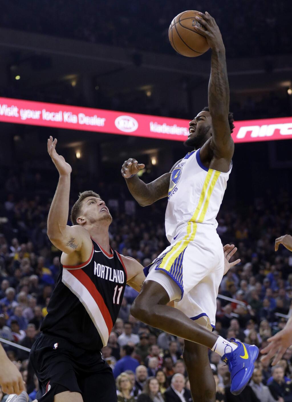 Golden State Warriors' Jordan Bell, right, drives to the basket as Portland Trail Blazers' Meyers Leonard (11) defends during the first half of an NBA basketball game Monday, Dec. 11, 2017, in Oakland, Calif. (AP Photo/Marcio Jose Sanchez)