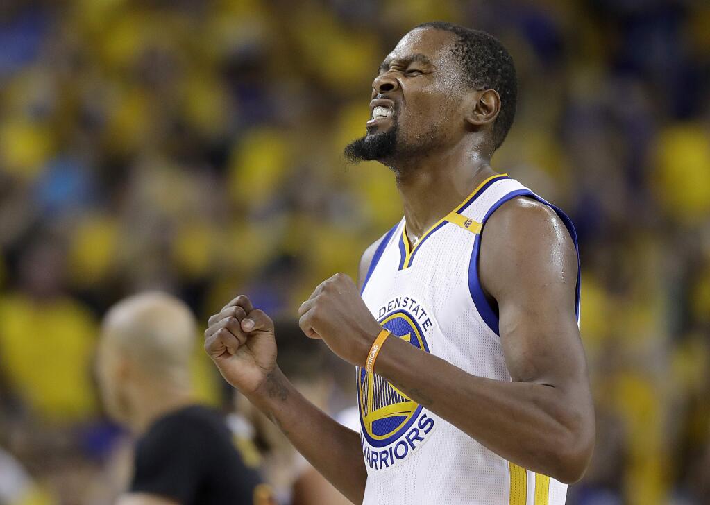 FILE - In this June 12, 2017, file photo, Golden State Warriors forward Kevin Durant reacts after scoring against the Cleveland Cavaliers during the second half of Game 5 of basketball's NBA Finals in Oakland, Calif. The 2017 NBA Champion Golden State Warriors signed Stephen Curry, Kevin Durant, Andre Iguodala, Shaun Livingston, Zaza Pachulia and David West to contracts, the team announced Tuesday, July 25, 2017. (AP Photo/Marcio Jose Sanchez, File)